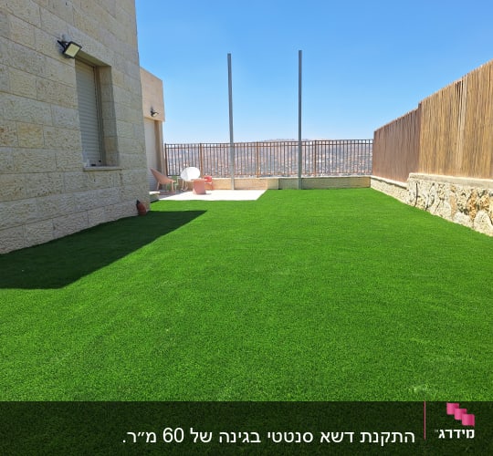 חצר עם דשא סינתטי ליד בית אבן